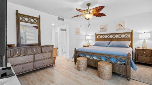 una camera da letto con un letto, un comò e uno specchio di Loggerhead Cay 451 a Sanibel