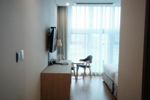 a room with a bed and a desk with a chair at Rosana Hotel in Seoul