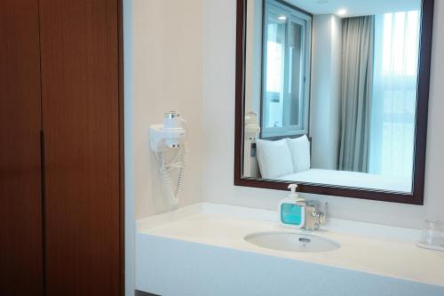 a bathroom with a sink and a mirror at Rosana Hotel in Seoul