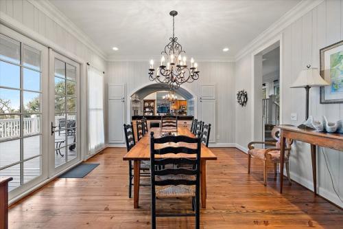 a dining room with a table and a chandelier at Chiltren By The Sea in Edisto Island
