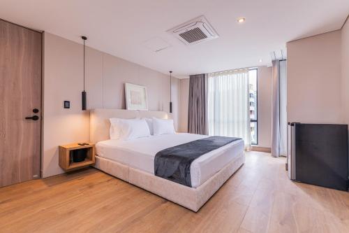 a bedroom with a large bed and a television at Jatisa Living by Housy in Medellín