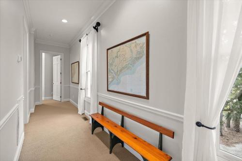 a hallway with a bench and a map on the wall at Chiltren By The Sea in Edisto Island