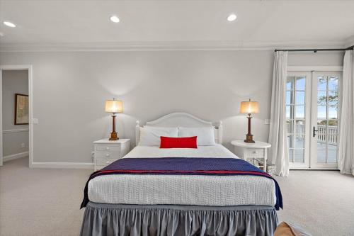 a bedroom with a large bed with a red pillow at Chiltren By The Sea in Edisto Island
