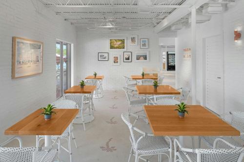 a restaurant with wooden tables and white chairs at Marriott Hutchinson Island Beach Resort, Golf & Marina in Stuart