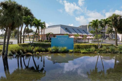 a pond in front of a building with palm trees at Marriott Hutchinson Island Beach Resort, Golf & Marina in Stuart