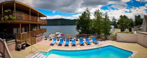 a hotel with a swimming pool with a view of a lake at Lake Crest Inn in Lake George
