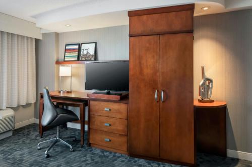 a hotel room with a desk and a television at Courtyard by Marriott Gaithersburg Washingtonian Center in Gaithersburg