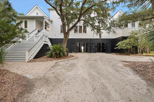 a white house with a driveway in front of it at Chiltren By The Sea in Edisto Island