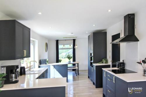 a kitchen with blue cabinets and a dining room at Bright & Stylish Bungalow Retreat in Attleborough in Attleborough