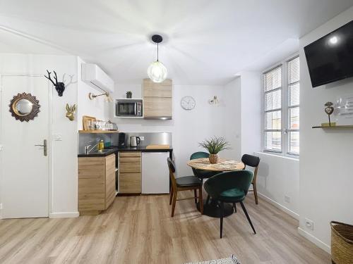 a kitchen and dining room with a table and chairs at O'BERCAIL in Tournon-sur-Rhône