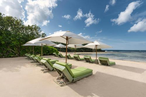 a row of chairs and umbrellas on a beach at Renaissance Bali Nusa Dua Resort in Nusa Dua