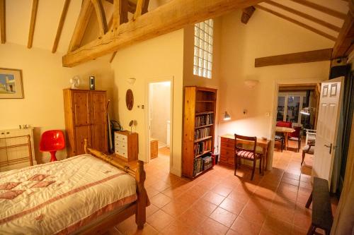 a bedroom with a bed and a dining room at Nature's Lodge in Wolverley