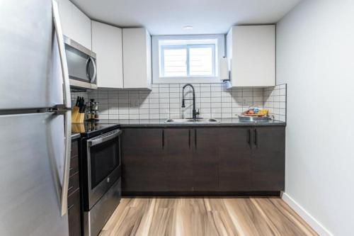 a kitchen with a sink and a refrigerator at Outdoor Sauna Hot Tub Playroom Port Dallhousie in St. Catharines