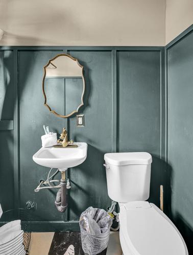 a bathroom with a toilet and a sink and a mirror at Stylish Casa Mina Downtown Free Parking in El Paso