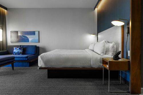 a hotel room with a bed and a desk with a laptop at Courtyard by Marriott Madison in Madison