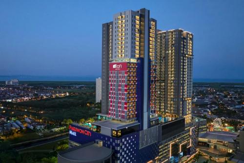 a view of a tall building at night at Aloft Surabaya Pakuwon City in Surabaya