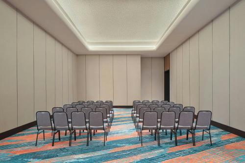 an empty room with rows of chairs in it at Aloft Surabaya Pakuwon City in Surabaya