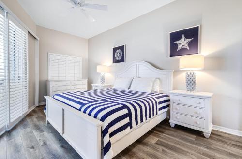 a white bedroom with a bed and two night stands at Shell Island Beach Club 7C in Sanibel