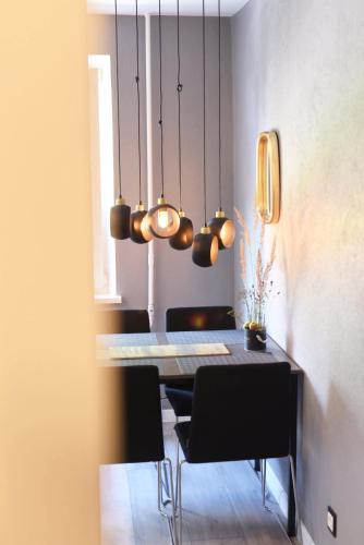 a dining room with a table and black chairs at LOCUSDO Apartment No.31 in Mažeikiai