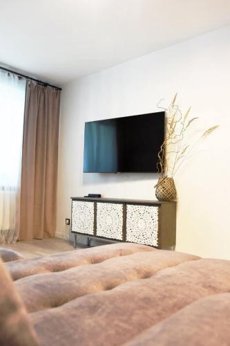 a living room with a flat screen tv on a wall at LOCUSDO Apartment No.31 in Mažeikiai