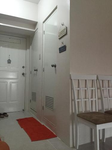 un corridoio con una porta e una sedia con un tappeto rosso di Apartment at Tagaytay Prime Residences a Tagaytay