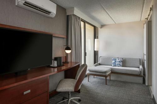 a hotel room with a flat screen tv and a couch at Courtyard by Marriott Los Angeles Pasadena/Monrovia in Monrovia