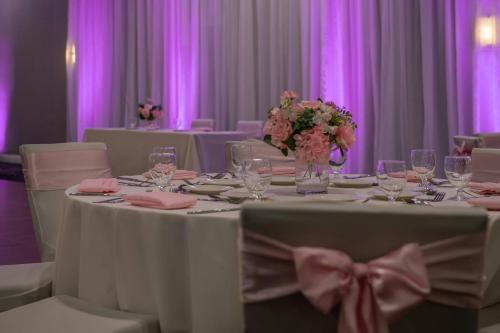 a table with glasses and flowers on top of it at Courtyard by Marriott Los Angeles Pasadena/Monrovia in Monrovia