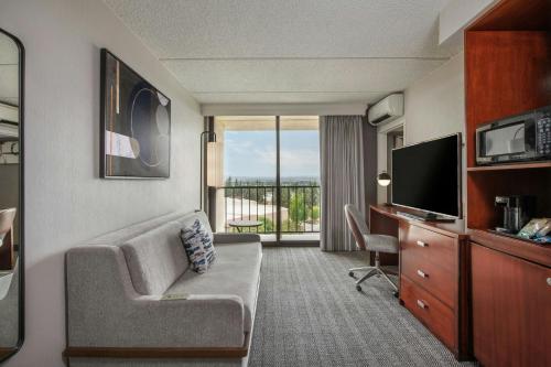 a living room with a couch and a television in a room at Courtyard by Marriott Los Angeles Pasadena/Monrovia in Monrovia