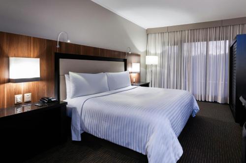 a hotel room with a large bed and a window at Marriott São Paulo Airport Hotel in Guarulhos