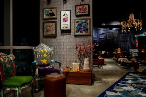 a living room with a chair and pictures on the wall at Moxy Charlotte Downtown in Charlotte