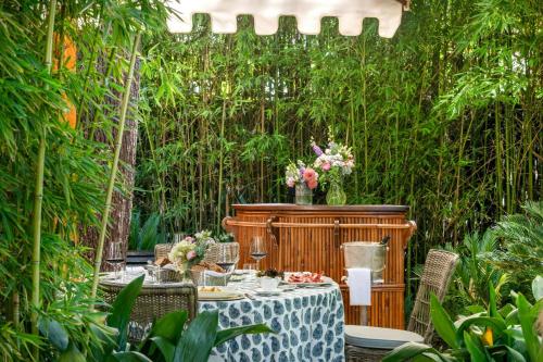 a garden with a table and chairs and plants at Santo Mauro, a Luxury Collection Hotel, Madrid in Madrid