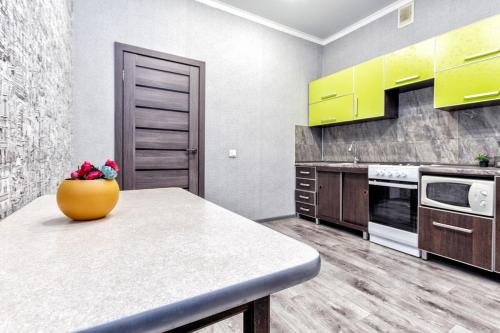 a kitchen with a table with a vase on it at Квартира ЖК Ирина in Pavlodar