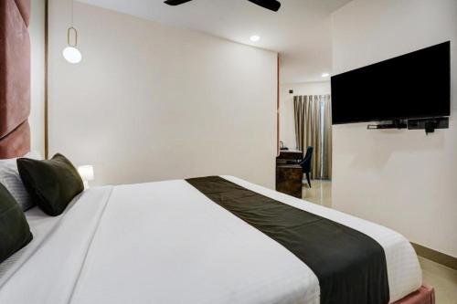 - une chambre avec un grand lit blanc et une télévision à écran plat dans l'établissement Hotel arvind, à Varanasi