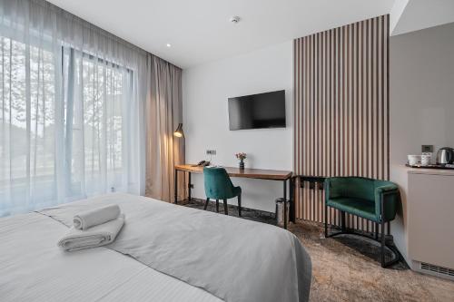 a bedroom with a bed and a desk and a television at iNova in Zagreb
