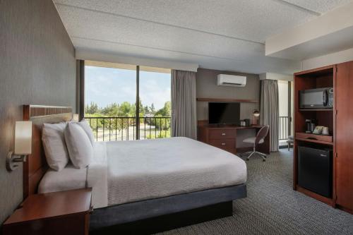 a hotel room with a bed and a balcony at Courtyard by Marriott Los Angeles Pasadena/Monrovia in Monrovia