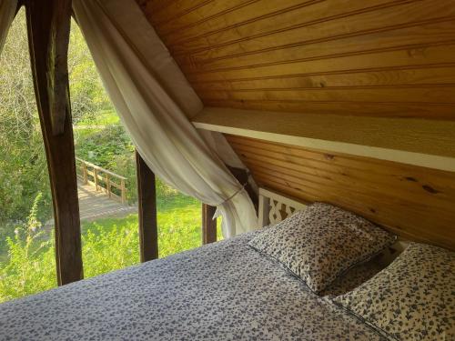 a bed in a room with a wooden ceiling at Le Manoir du Perroy in Saint-Wandrille-Rançon