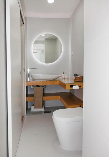 a bathroom with a white toilet and a mirror at Cozy apartment downtown in Ponte da Barca