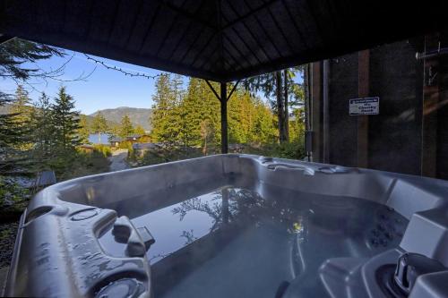 a bath tub with a view of a tree at The Great Escape - Port Renfrew & Bunkhouse in Port Renfrew