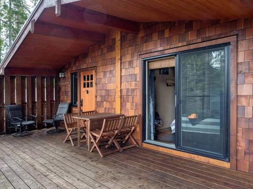 a patio with a table and chairs on a deck at The Great Escape - Port Renfrew & Bunkhouse in Port Renfrew