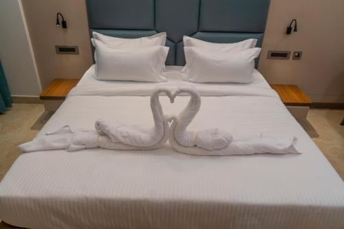 two swans made out of towels on a bed at Hotel K Fortune in Kurnool