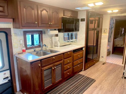 a kitchen with wooden cabinets and a sink at The Great Escape - Shirley & Bunkhouse in Sooke