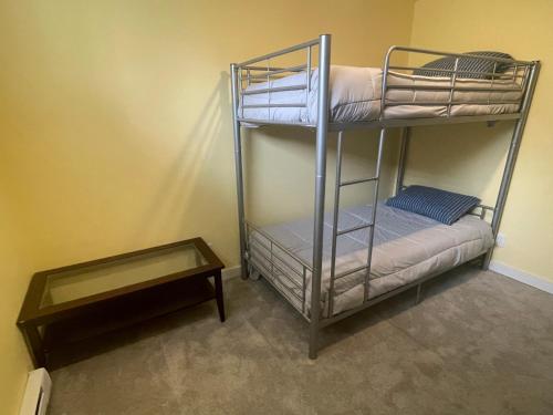 a couple of bunk beds in a room with a table at The Great Escape - Shirley & Bunkhouse in Sooke