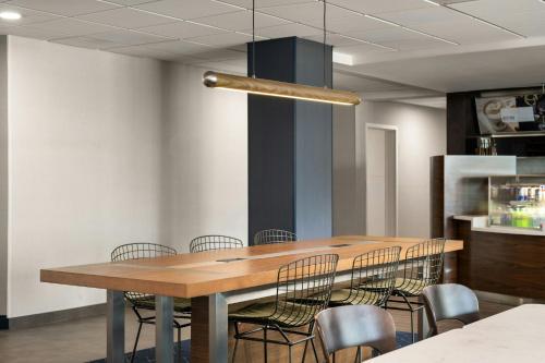 a dining room with a wooden table and chairs at Courtyard Brunswick in Brunswick