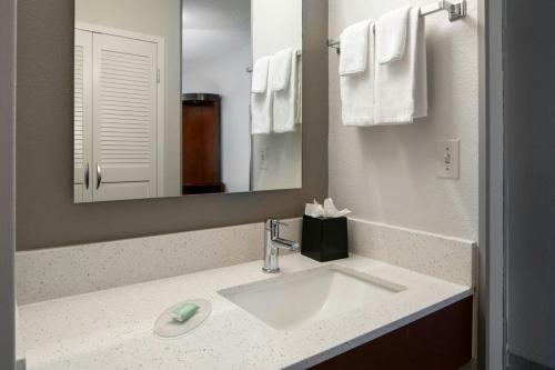 a bathroom with a sink and a mirror and towels at Courtyard Gulf Shores Craft Farms in Gulf Shores