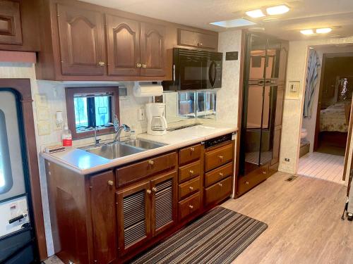 a kitchen with wooden cabinets and a sink at The Great Escape - Shirley & Bunkhouse in Sooke