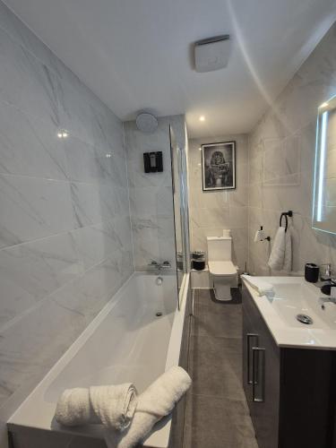 a bathroom with a tub and a toilet and a sink at Cotswold Escape 15 - City Centre in Bradford