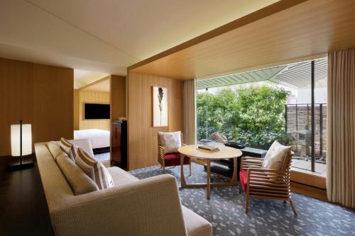 a living room with a table and chairs and a bedroom at The Ritz-Carlton Kyoto in Kyoto