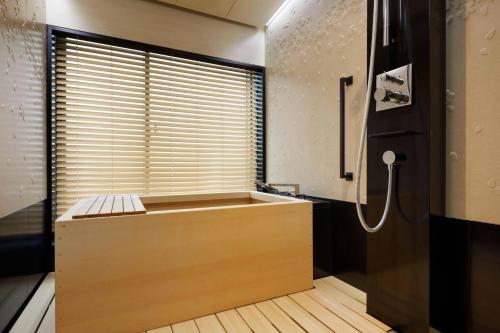 a bathroom with a large tub and a shower at The Ritz-Carlton Kyoto in Kyoto
