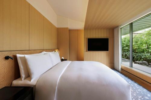 a large white bed in a room with a window at The Ritz-Carlton Kyoto in Kyoto
