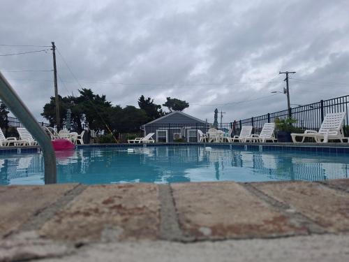 a large swimming pool with chairs and a fence at The Breezeway Motel & Resturant in Topsail Beach